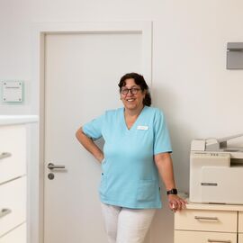 Praxishelferin im Büroraum mit Drucker