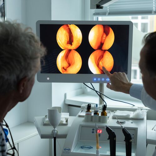 Situation im Behandlungszimmer: Dr. Lübben und Patient schauen sich Fotos vom Ohr an